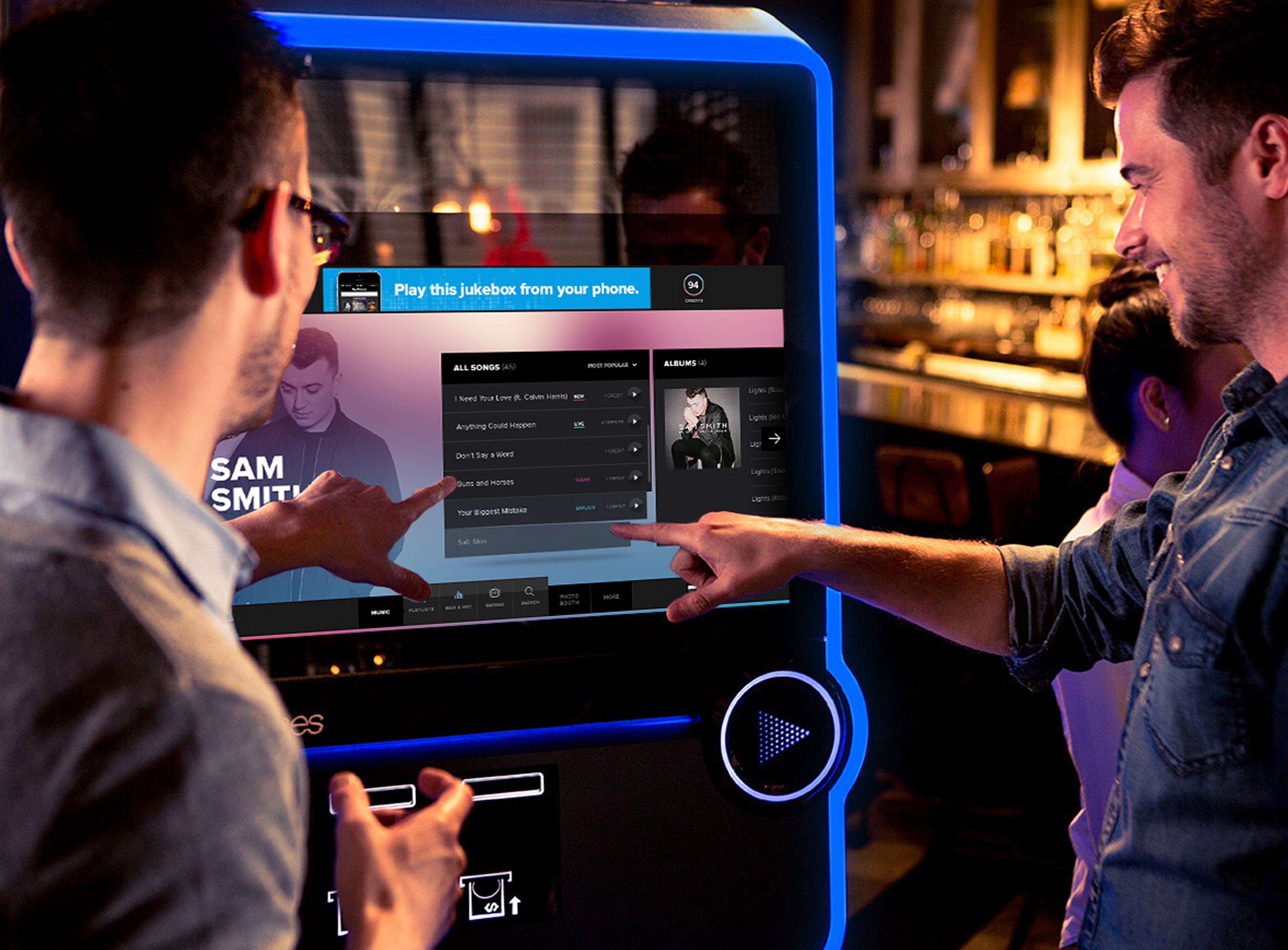 Two men choosing from a jukebox